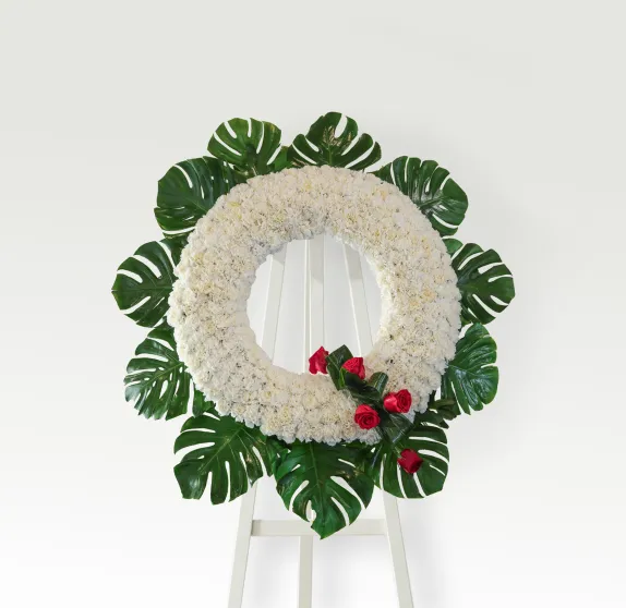 Corona de clavel blanco con detalle de rosas rojas