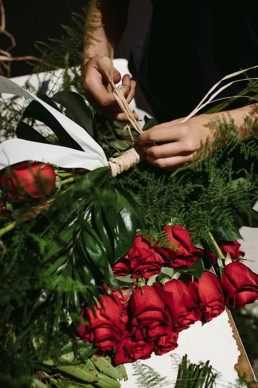 Persona preparando un ramo de rosas