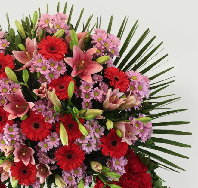 Corona de clavel rojo y cabezal variado