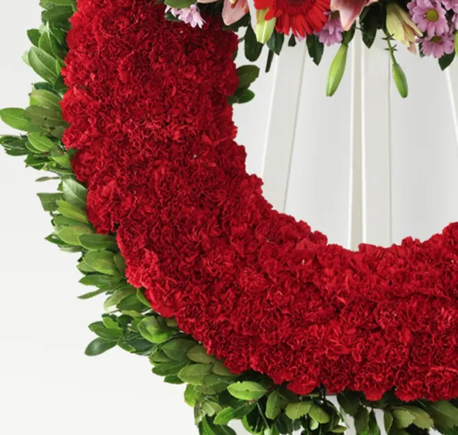 Corona de clavel rojo y cabezal variado