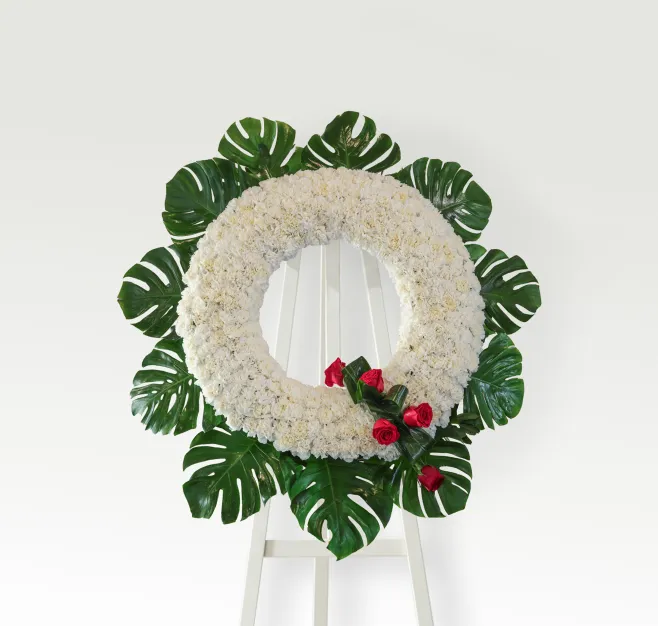 Corona de clavel blanco con detalle de rosas rojas