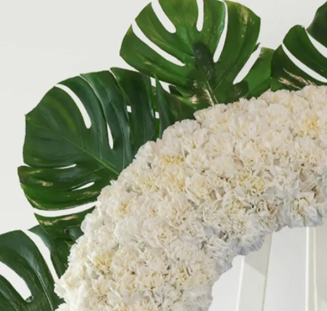 Corona de clavel blanco con detalle de rosas rojas